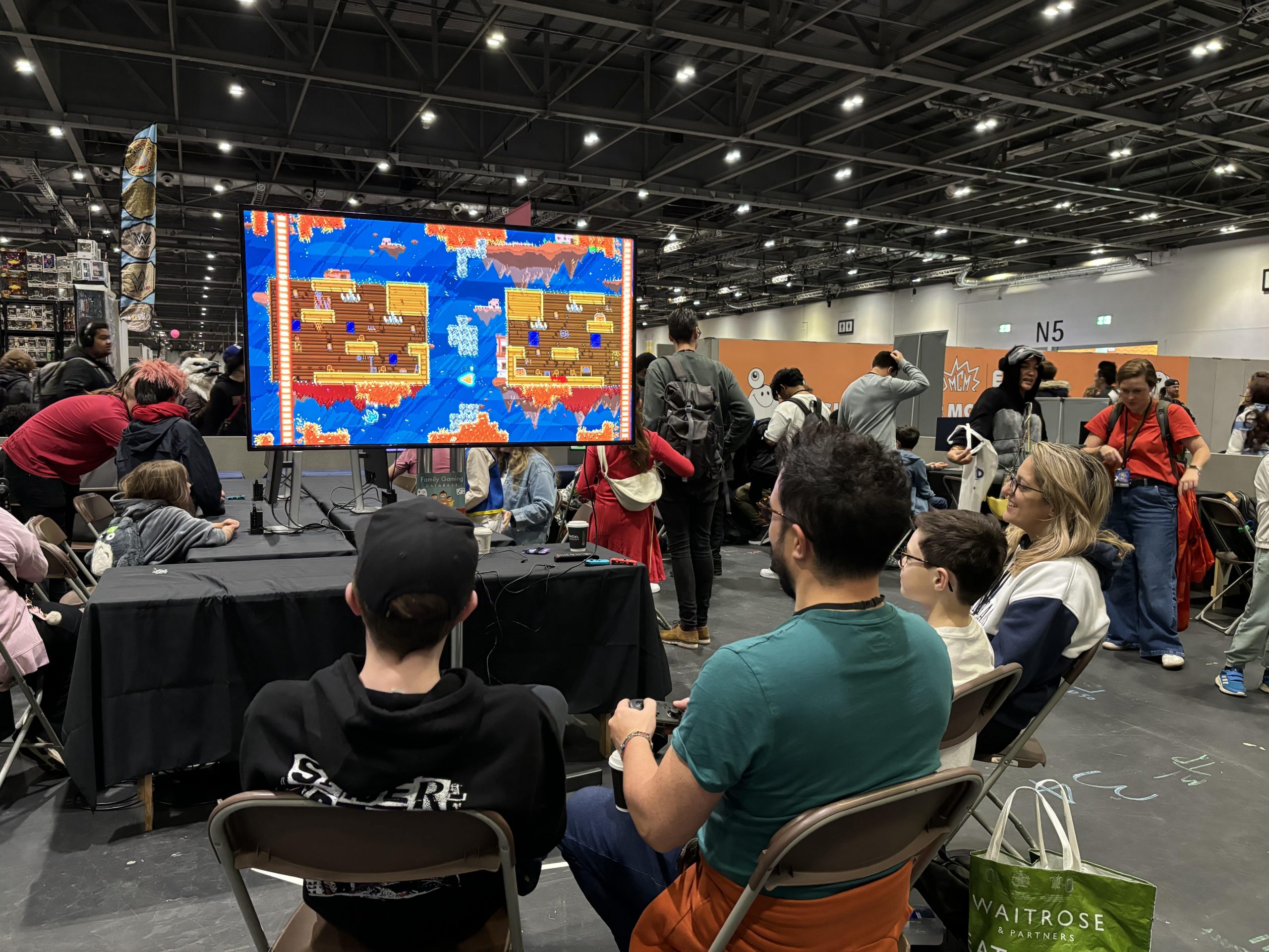 People sitting on chairs at BETT Event playing a video game